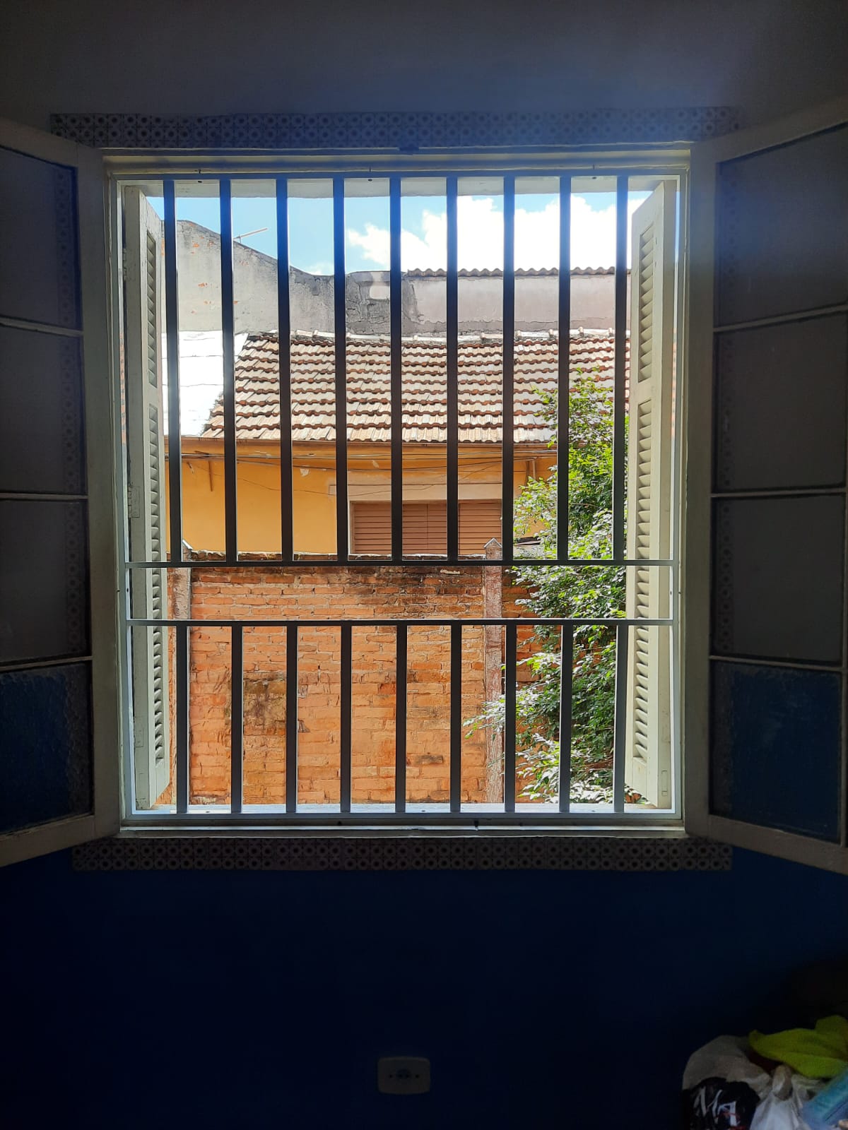 Grade de proteção para janela com estrutura branca.